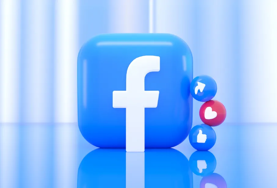 A blue Facebook logo icon with small share, like, and heart reaction spheres